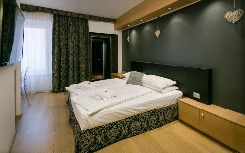 a bedroom with a large white bed with a green wall at Boutique Exclusive B&B in Trento