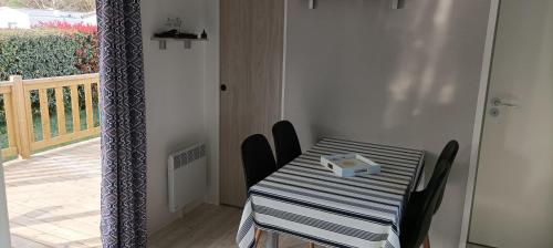 a table with a blue and white striped table and chairs at "Mar e sou" 412 Camping La Réserve SIBLU in Gastes