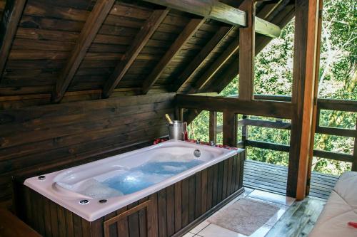 uma banheira de hidromassagem numa casa de madeira em Cabanas dos Plátanos em Gramado