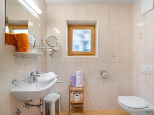 a white bathroom with a sink and a toilet at Apartment Rosa-6 by Interhome in Mayrhofen