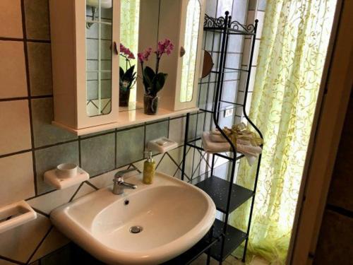 łazienka z umywalką, lustrem i oknem w obiekcie Locazione in Appartamento sita in via Ponte di Ferro 2 b w mieście Gualdo Cattaneo