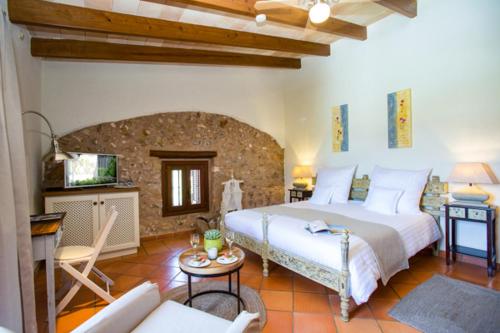 a bedroom with a large bed and a living room at Casa Font i Roig in Maria de la Salut