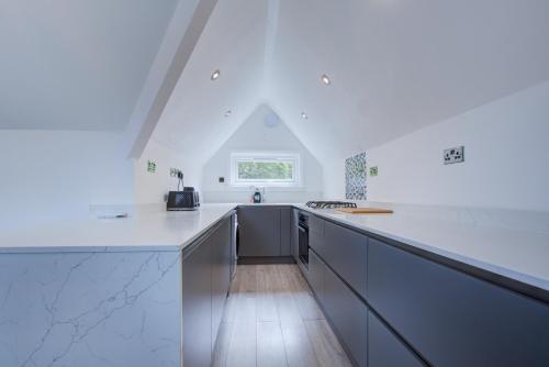 a kitchen with white counter tops and a window at Large 3 Bedroom Apartment with Free Parking near Beach and Meyrick Park Fast WiFi in Bournemouth