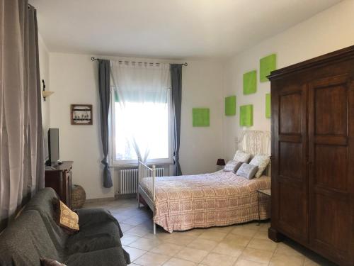 ein Schlafzimmer mit einem Bett, einem Fenster und einem Sofa in der Unterkunft Da Scilla in Punta Marina