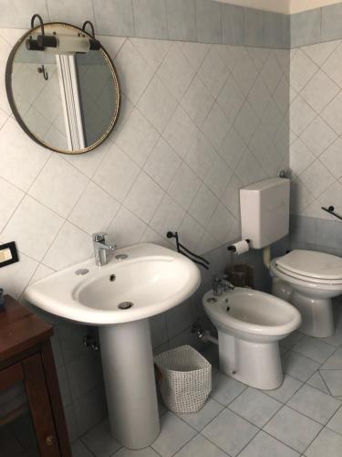 a bathroom with a sink and a toilet and a mirror at Da Scilla in Punta Marina