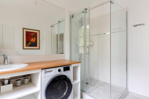 - un lave-linge dans la salle de bains pourvue d'une douche en verre dans l'établissement Eiffel Tower Lourmel Residence, à Paris
