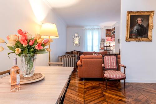 un salon avec un vase de fleurs sur une table dans l'établissement Eiffel Tower Lourmel Residence, à Paris