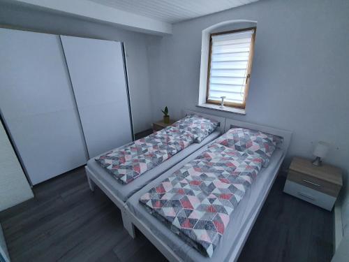 ein kleines Schlafzimmer mit 2 Betten und einem Fenster in der Unterkunft Ferienwohnung Bei Vogel in Geroldsgrün
