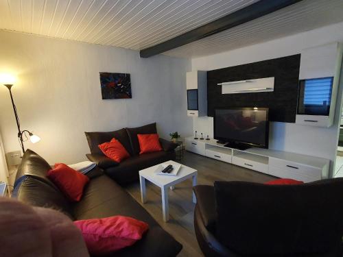 sala de estar con sofá y TV de pantalla plana en Ferienwohnung Bei Vogel, en Geroldsgrün