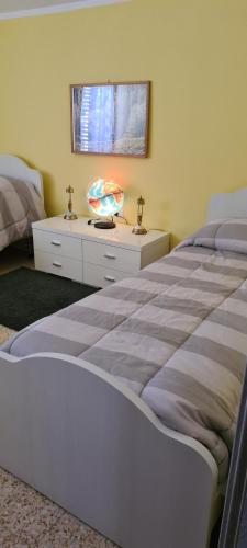 a bedroom with two beds and a table with a bowl on it at Appartamenti Il Leone in Pienza