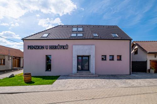a white building with a sign on the side of it at Vinařství Herůfek in Zaječí