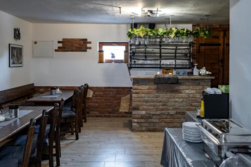 een restaurant met tafels en stoelen en een bakstenen muur bij Vinařství Herůfek in Zaječí