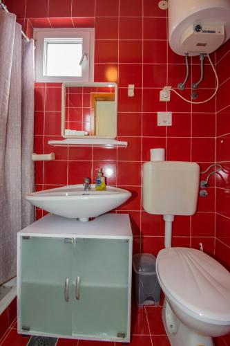 a red bathroom with a toilet and a sink at Studio Gabi, Premantura in Premantura
