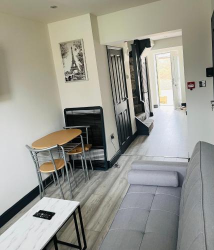 a living room with a couch and a table and chairs at Old Green Lantern, Private En-suite Double Bedroom in Aveley
