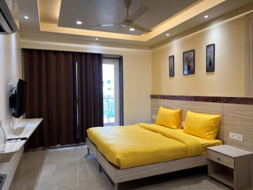 una camera con letto giallo e televisore di Windchime 853 a Gurgaon