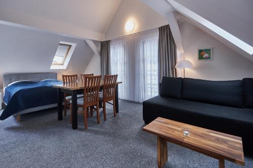 sypialnia z łóżkiem, stołem i kanapą w obiekcie Apartamenty Świnoujście - Villa Stil 1 w Świnoujściu