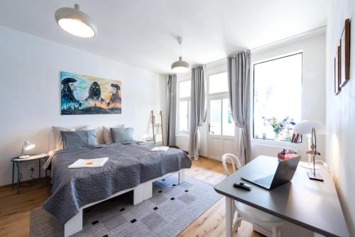a bedroom with a bed and a desk with a laptop at Apartment MERAN in Mariánské Lázně