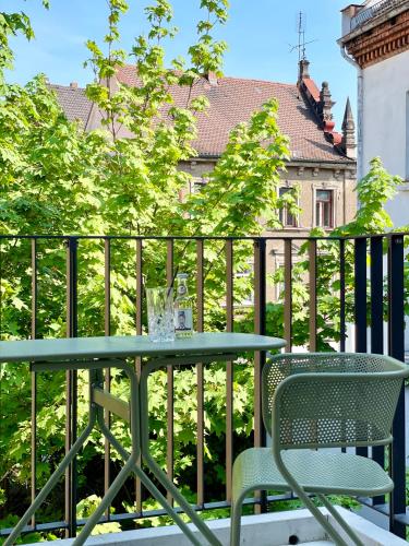 a table and chair on a balcony with a fence at zeitwohnhaus SUITE-HOTEL & SERVICED APARTMENTS in Erlangen