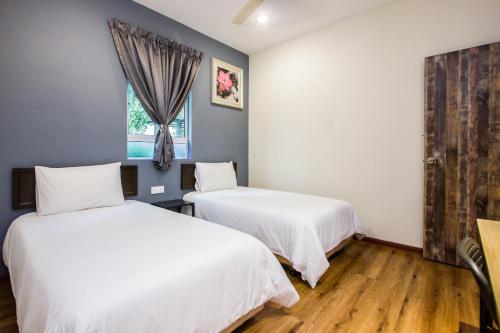 a bedroom with two beds and a window at Surprised Homestay Butterworth in Butterworth