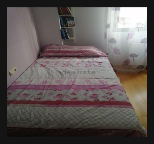 małą sypialnię z łóżkiem z kołdrą w obiekcie Habitación w Pampelunie