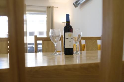 a bottle of wine sitting on a table with two glasses at Hermon Suites in Majdal Shams