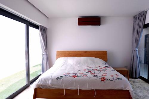 a bedroom with a bed with a floral bedspread at Swiss House 5 in Pattaya South