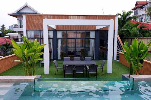 a house with a table and chairs next to a swimming pool at Swiss House 5 in Pattaya South