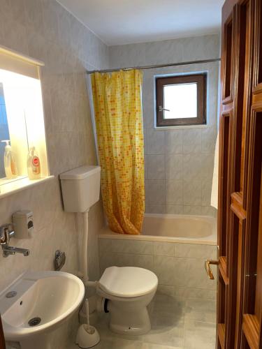 a bathroom with a toilet and a tub and a sink at Apartments Top of Budva in Budva