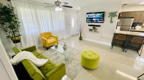 a living room with a green couch and a yellow chair at Cozy Comfy House in Pembroke Pines