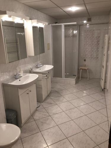 un bagno bianco con 2 lavandini e una doccia di Apartment 1 a Špindlerův Mlýn