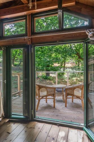 a screened in porch with a table and benches at Hani Kastania - Chania retreat for families and groups for holidays and workshops in Sémbronas