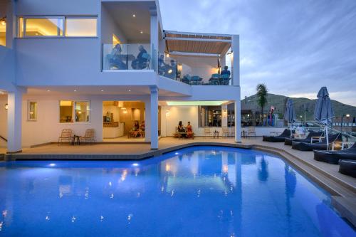a house with a large swimming pool in front of it at Mare Boutique in Georgioupolis