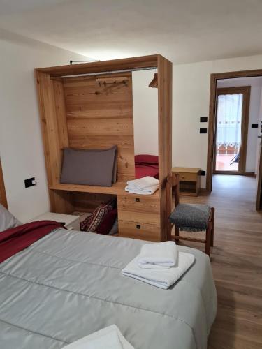 a bedroom with a bed and a desk and a chair at Casa Tiziano e Nila in Santo Stefano di Cadore