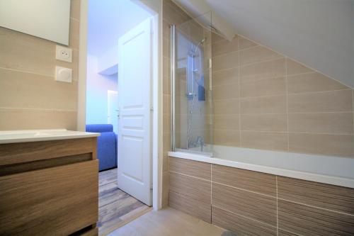 uma casa de banho com um chuveiro, um lavatório e uma banheira em Appart'hôtel La Tour em La Tour-du-Pin