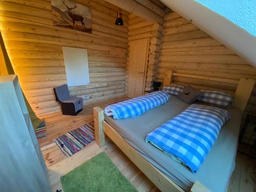a bedroom with a bed in a log cabin at Alpenchalet Grabner Alm am Präbichl in Almhäuser