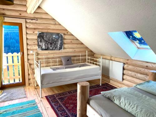 1 dormitorio con 1 cama en una cabaña de madera en Alpenchalet Grabner Alm am Präbichl en Almhäuser