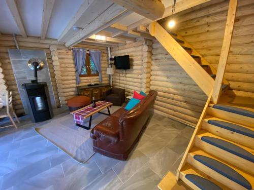 a living room with a staircase in a log cabin at Alpenchalet Grabner Alm am Präbichl in Almhäuser