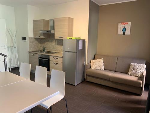 a kitchen with a couch and a table and a refrigerator at HH Hermoso Housing VALENZA in Valenza