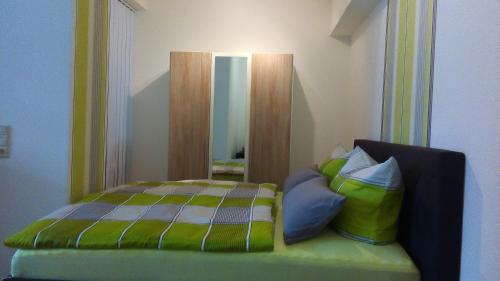 Dormitorio con cama con espejo y almohadas en Apartment Halmis FeWo WR, en Wernigerode