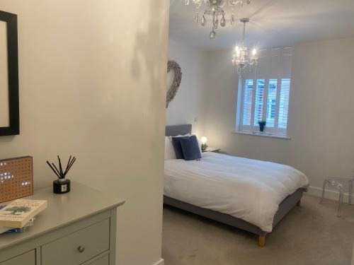 a bedroom with a bed and a table and a chandelier at UNRIVALLED LOCATION FIVE STAR WORCESTER APARTMENT in Worcester