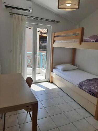 a bedroom with a bed and a desk and a window at Ionian Apartment, Sami in Sami