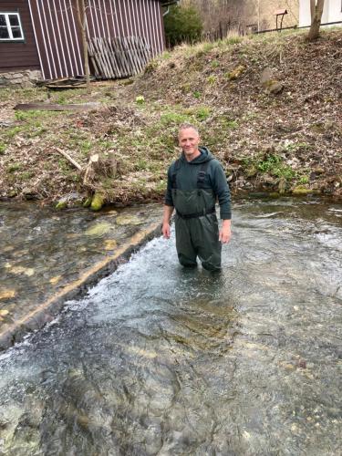 a man standing in the water in a stream at Rakouská vila in Bělá pod Pradědem