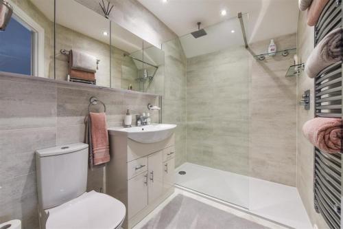 La salle de bains est pourvue de toilettes, d'un lavabo et d'une baignoire. dans l'établissement Luxury 4 Bedroom Detached House, à Waterlooville