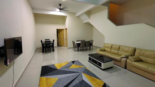 Sentosa2Stay Gong Badak Kuala Terengganu في كامبونغ غونغ بدك: غرفة معيشة مع أريكة وطاولة