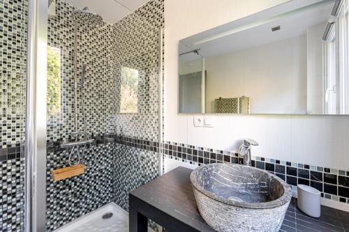 une salle de bain avec un lavabo, une baignoire et un miroir dans l'établissement Le Panoramic 2 par Dodo-a-Cassis, à Cassis