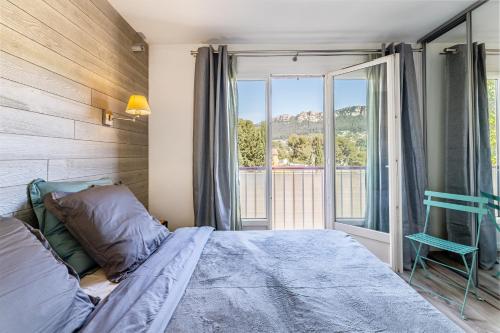 une chambre avec un lit et une grande fenêtre dans l'établissement Le Panoramic 2 par Dodo-a-Cassis, à Cassis