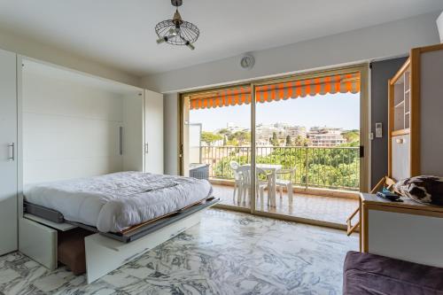 une chambre avec un lit et une grande fenêtre dans l'établissement L'Also, à Antibes