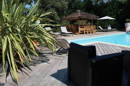 a swimming pool with chairs and a gazebo at Au K'Ré in Rivedoux-Plage