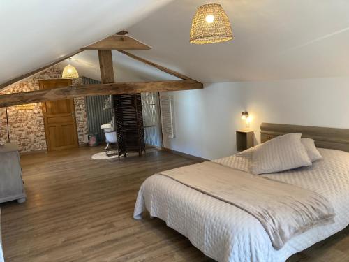 een slaapkamer met een bed en een houten vloer bij Chez Iréne in Villiers-aux-Chênes