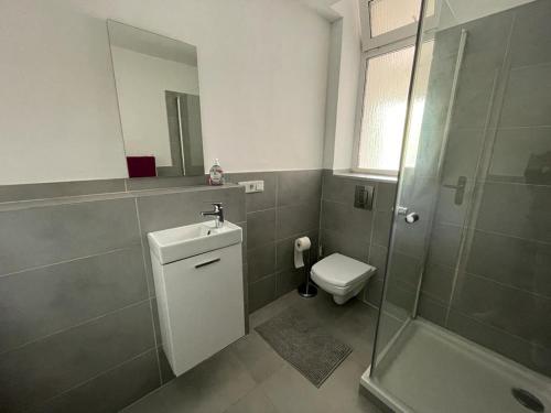 a bathroom with a toilet and a sink and a shower at Bungalow mit Terrasse in Regensburg